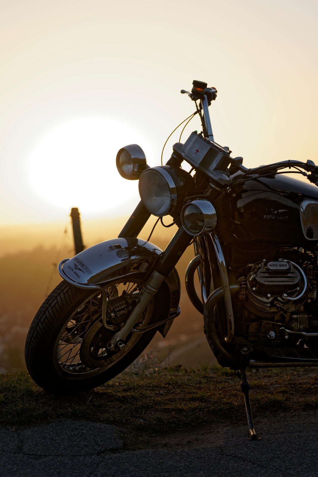 Motorrad am Straßenrand vor Sonnenuntergang mit Blick auf die Landschaft